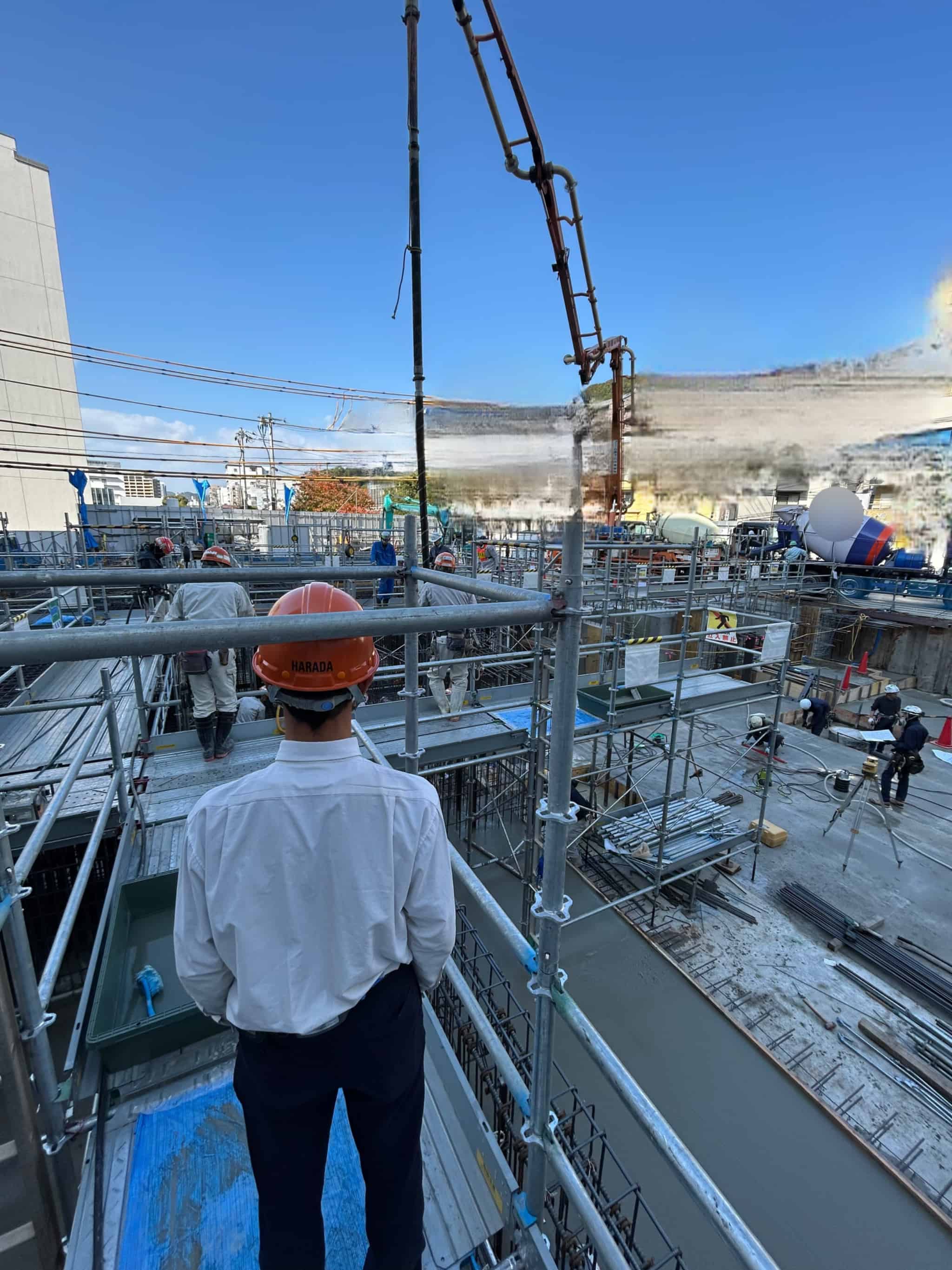 オフィスビルの基礎工事の見学風景(実際にコンクリート打設に使うバイブレーターに触れていただきました) | 次世代の職人を育てる建設会社|高校生の職場見学会を開催しました | お知らせ | 株式会社原田組